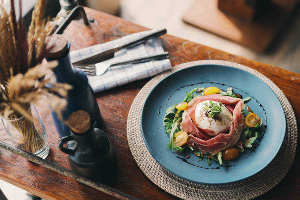 istock Healthy Italian salad with buffalo mozzarella and prosciutto on rustic table decorations. 1357850081