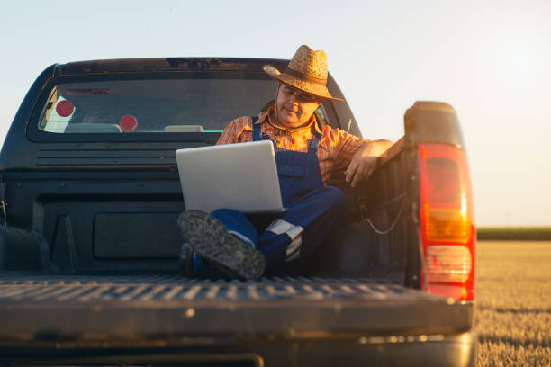 istock Farmer use new technology for agronomy. Farmer calculates earnings. 1357850905