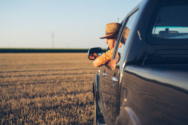 istock Young man in straw hat driving truck 1357851719