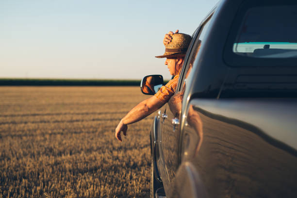 istock Young man in straw hat driving truck 1357851760