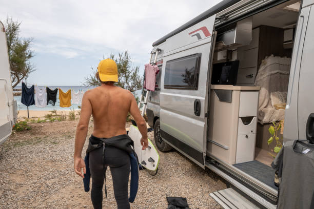 surfer przygotowuje się w swojej furgonetce gotowej do sesji falowej - class a motorhome zdjęcia i obrazy z banku zdjęć