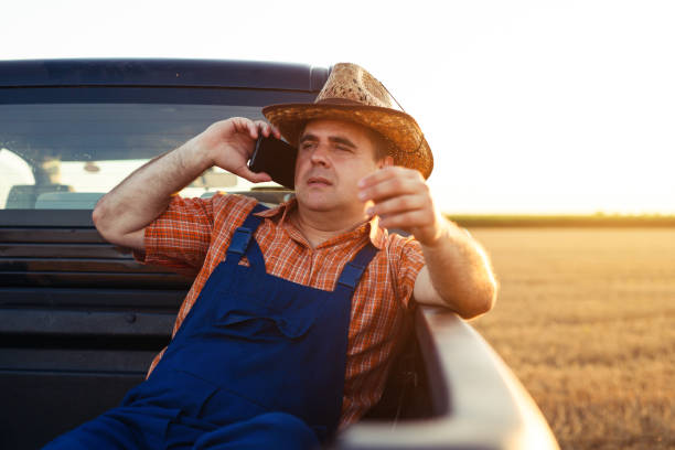 istock Farmer talking on smart phone. Life on a farm 1357852288