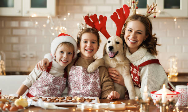 feliz madre de familia, dos niños con perro golden retriever en la cocina, preparando galletas de navidad - 18638 fotografías e imágenes de stock