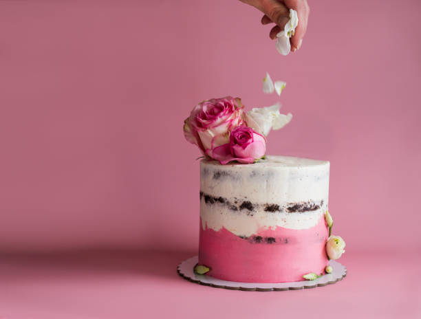 istock Crop person decorating cake with flowers 1357853308