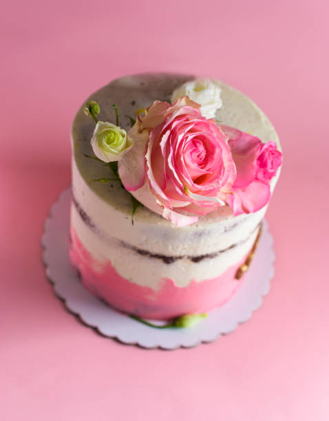istock Cake decorated with natural roses on a pink background. Selective focus 1357853338