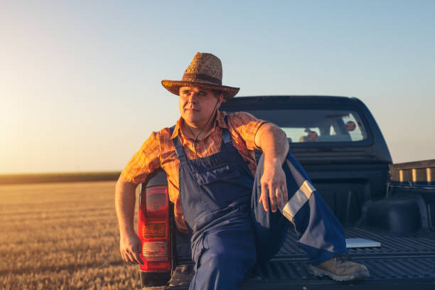 Farmer sitting on back of truck.