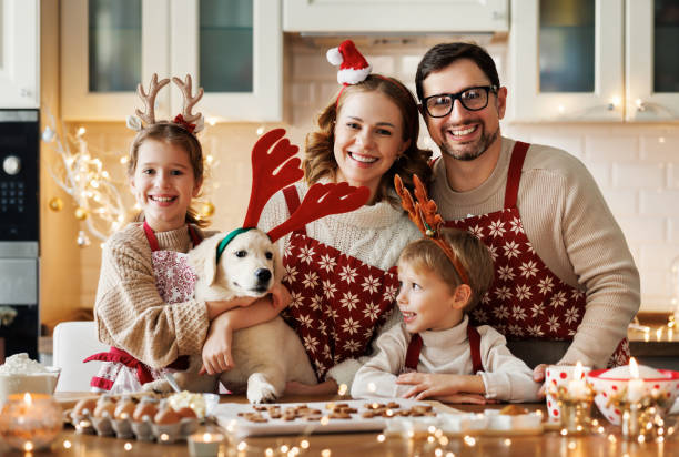 felices padres de familia con dos hijos y cachorro de golden retriever mientras hacen galletas de navidad en casa - 18640 fotografías e imágenes de stock