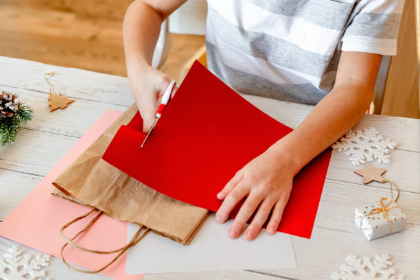 istock DIY Step-by-step guide instructions for Christmas paper bag for children. New year pack with Santa made of colored paper, glue and scissors. Fine motor skills. Winter holidays time. Handmade. Step 2 1357854694