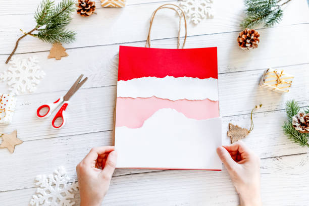 istock DIY Step-by-step guide instructions for Christmas paper bag for children. New year pack with Santa made of colored paper, glue and scissors. Fine motor skills. Winter holidays time. Handmade. Step 7 1357854723