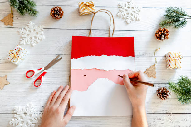 DIY Step-by-step guide instructions for Christmas paper bag for children. New year pack with Santa made of colored paper, glue and scissors. Fine motor skills. Winter holidays time. Handmade. Step 8 instrucciones de la guía paso a paso para la bolsa de papel de navidad para niños. paquete de año nuevo con papá noel hecho de papel de colores, pegamento y tijeras. motricidad fina. tiempo de vacaciones de invierno. hecho a mano. paso 8