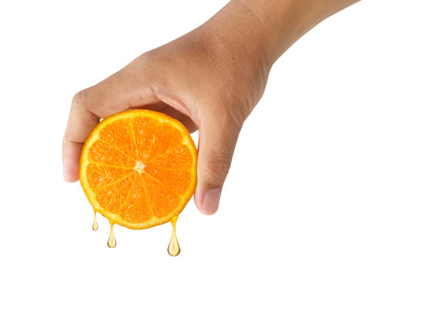 istock hand holding slice of orange isolated on white background 1357856718