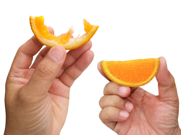 istock hand holding slice of orange isolated on white background 1357857301