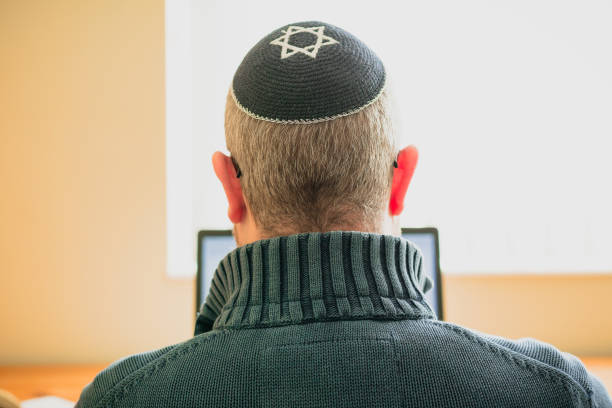 istock Jewish man wearing skull cap working from home 1357857411