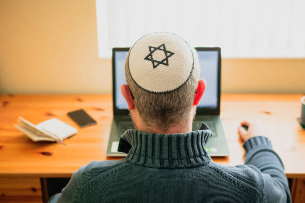 istock Jewish man wearing skull cap working from home 1357857416