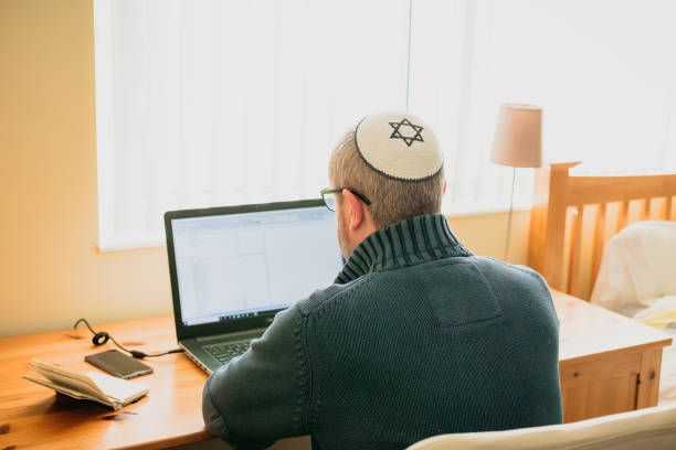istock Jewish man wearing skull cap working from home 1357857566
