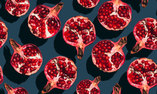 istock Seamless pattern of halves of pomegranate on a blue background. 1357858165