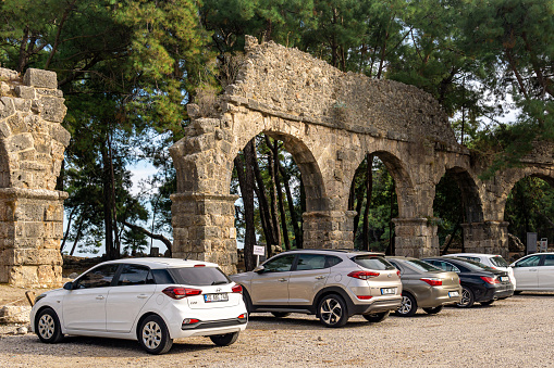 Phaselis, Turkey - November 08, 2021: car parking near the ruins of the ancient Roman aqueduct