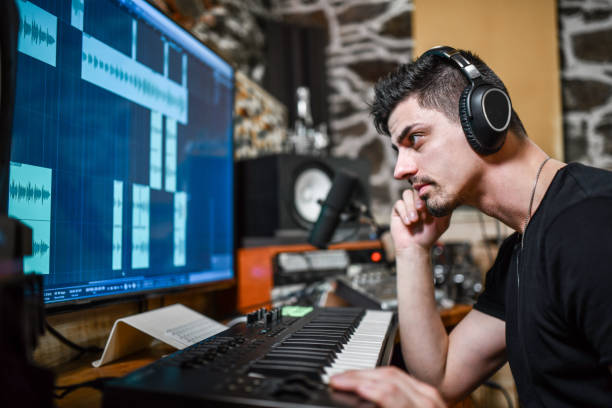 istock Producer Listening To Song Before Programming Beats On MIDI Keyboard 1357858872