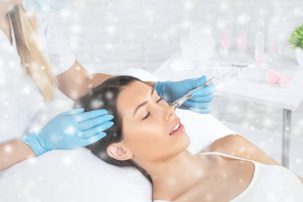 el cosmetólogo realiza el procedimiento microdermoabrasión de la piel de la cara de una hermosa niña en un salón de belleza. cosmetología y cuidado profesional de la piel. - dermatology dermabrasion surgery medical fotografías e imágenes de stock