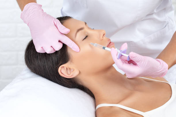 kosmetolog wykonuje odmładzające zastrzyki przeciwzmarszczkowe na twarz pięknej kobiety. kobieca kosmetologia estetyczna w salonie kosmetycznym. - healthcare and medicine beauty spa botox injection hyaluronic acid zdjęcia i obrazy z banku zdjęć