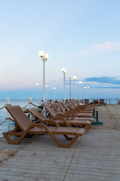 brown sunbeds on a wooden pier