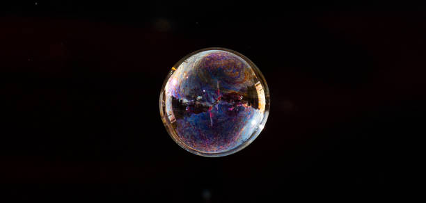 istock Soap bubble floating in mid air with a black background 1357860736