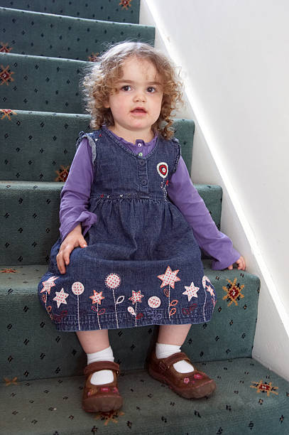 istock Two year old girl sitting on stairs 135786139