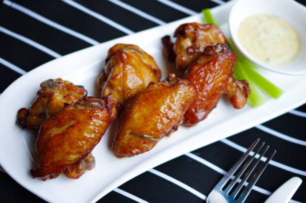 istock Roasted honey chicken wings and drumsticks on white plate top view 1357861510