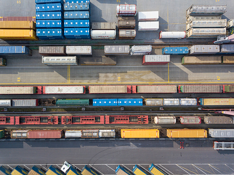 Aerial view of trains and wagons on numerous adjacent tracks in a railroad freight terminal. Location: Wels, Austria.