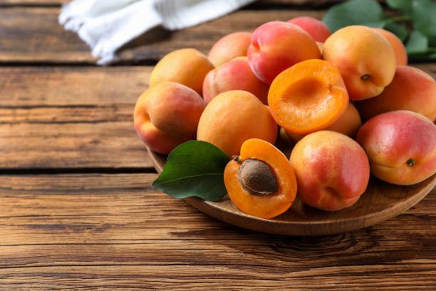 istock Delicious fresh ripe apricots on wooden table 1357861666