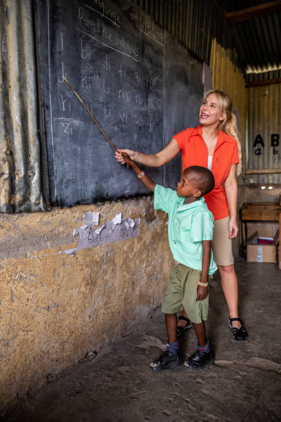 enseñanza voluntaria en áfrica, escuela cerca de la reserva de caza masai mara en kenia - african descent africa african culture classroom fotografías e imágenes de stock