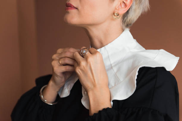 abgeschnittenes bild einer modefrau in einem vintage-schwarz-weiß-kleid mit stilvollem kragen - jabot stock-fotos und bilder