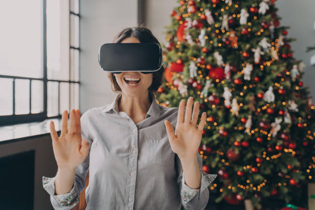 istock Impressed europian lady using VR googles while spending Christmas at home 1357862034