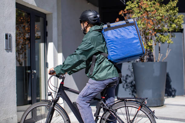 istock deliveryman on electric bicycle arriving to destination 1357862943