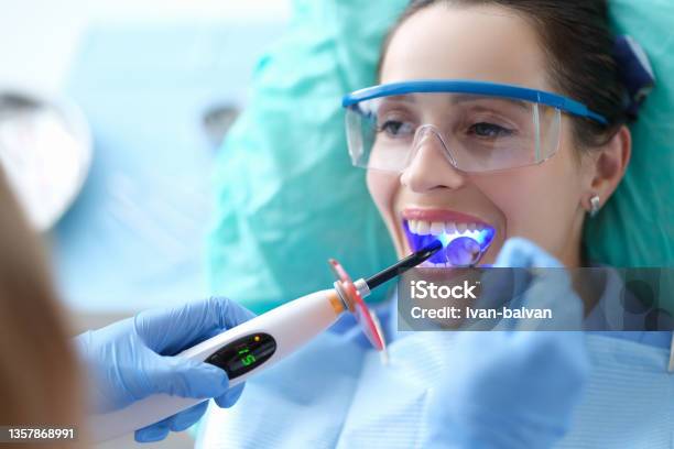 Dentist Works With Dental Polymerization Lamp In Oral Cavity Stock Photo - Download Image Now