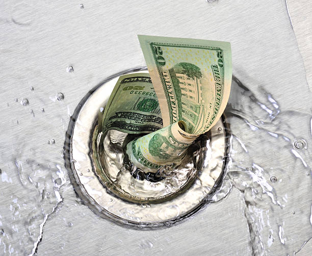 istock Wasted money going down the sink drain 135787045