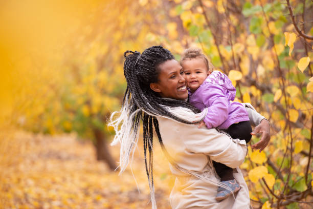 woman and child among the trees with autumn leaves. - family african ethnicity black african descent imagens e fotografias de stock