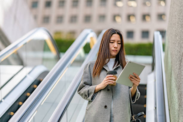istock Mixed-race businesswoman using digital-tablet while commuting in city 1357870850