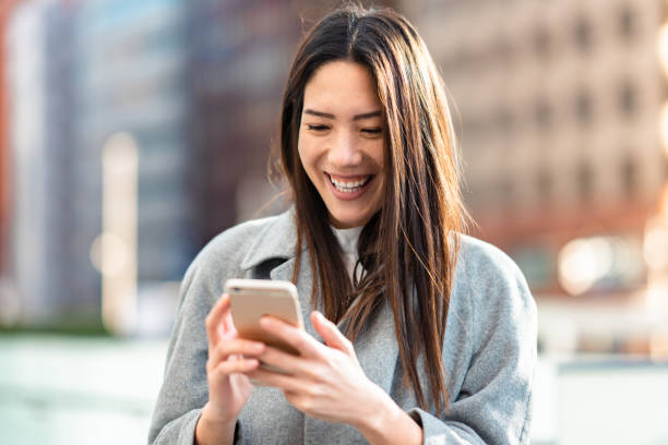 istock Mixed-race businesswoman using smart phone while commuting in city 1357870900