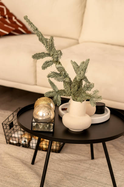 istock Festive home interior.A light sofa, a table with a vase and fir branches. Christmas decorations on the table.New Year and Christmas concept. 1357871722