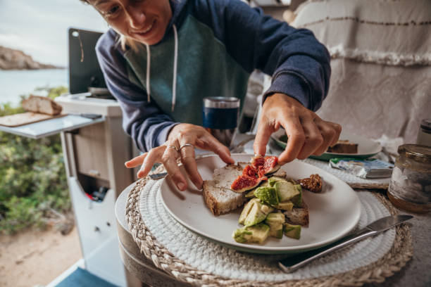 istock Woman prepares breakfast in her van, beach view 1357874807