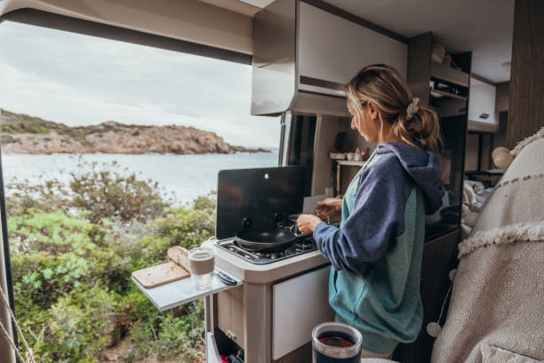 istock Woman prepares hot tea in her van, beach view 1357875014