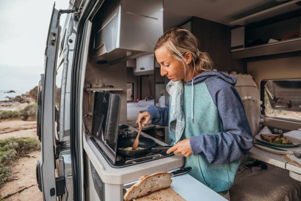 istock Young travel woman in her camper van preparing breakfast 1357875484