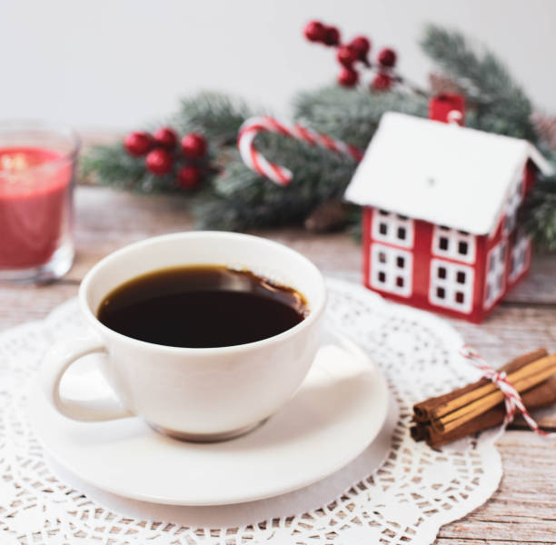 istock A white cup with black coffee and other Christmas decorations are on a light background on the table. 
Square image. 1357875650