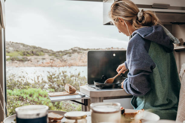 istock Young travel woman in her camper van preparing breakfast 1357875702