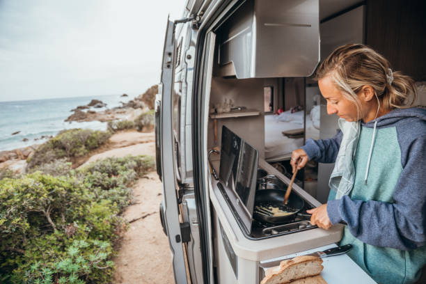 istock Young travel woman in her camper van preparing breakfast 1357875801