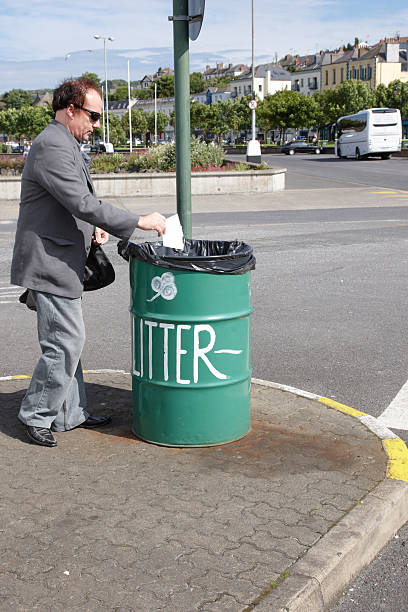 istock Man putting litter in green bin 135787626