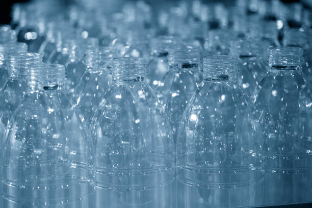 飲料水工場での充填プロセスのためのコンベアベルトの空のペットボトル。 - bottling plant bottle filling production line ストックフォトと画像