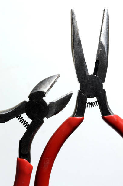 istock nippers and pliers with red handles on a light background close-up. 1357878520