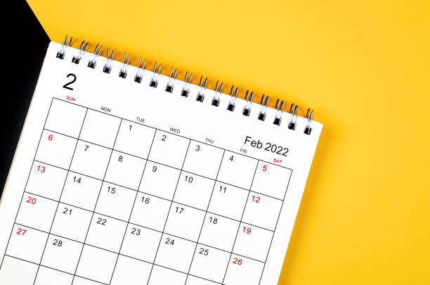 istock February 2022 desk calendar on yellow and black background. 1357878576